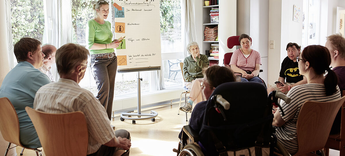 Gemeinsam lernen und weiterkommen: ein Referent spricht vor einem Kreis von Menschen mit und ohne Behinderung. Inklusive Fortbildung in Ulm gibt es bei L³.