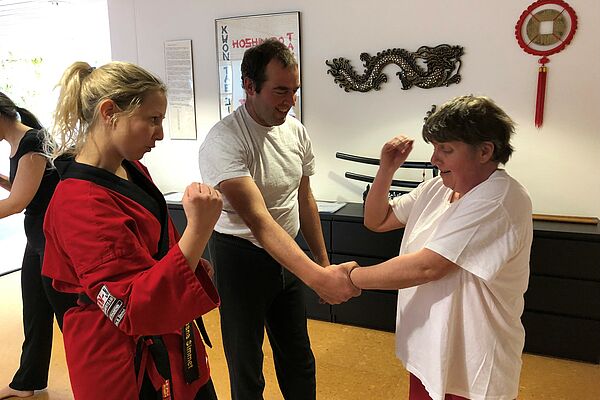 Kampfsportlehrer mit Schülern aus inklusiver Freizeitgruppe