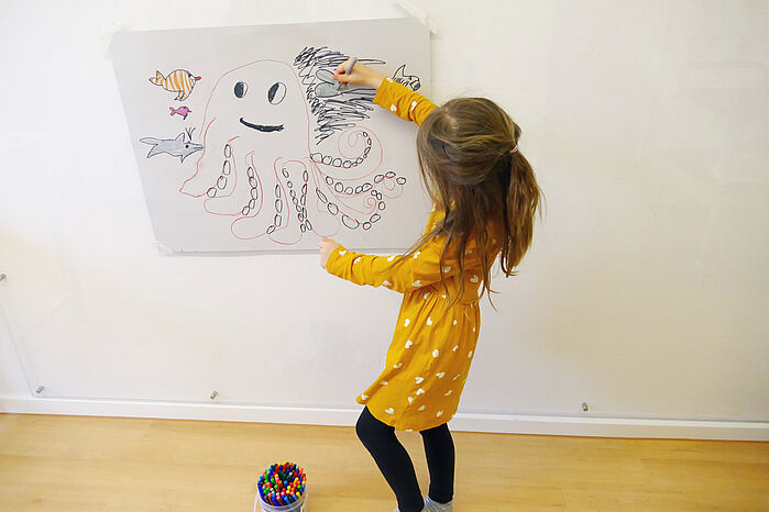 Ein Mädchen malt einen Tintenfisch - Frühförderung