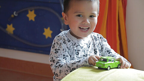 Lachender Junge spielt im Integrativen Kindergarten Lindennest