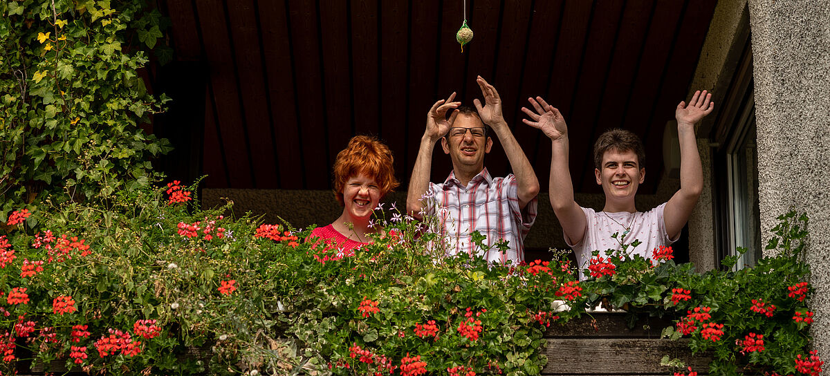 Wohnen für Menschen mit Behinderung im Wohnheim Senden - Drei Bewohner winken vom Balkon