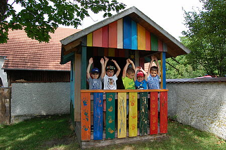 Fröhliche Kinder in einem bunten Spielhaus 